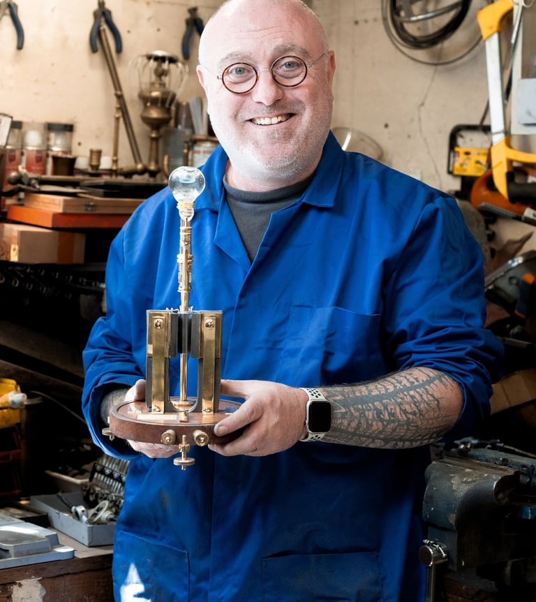 Mains de Yann Franconie, artisan fabricant de luminaires présentant une lampe dans son atelier