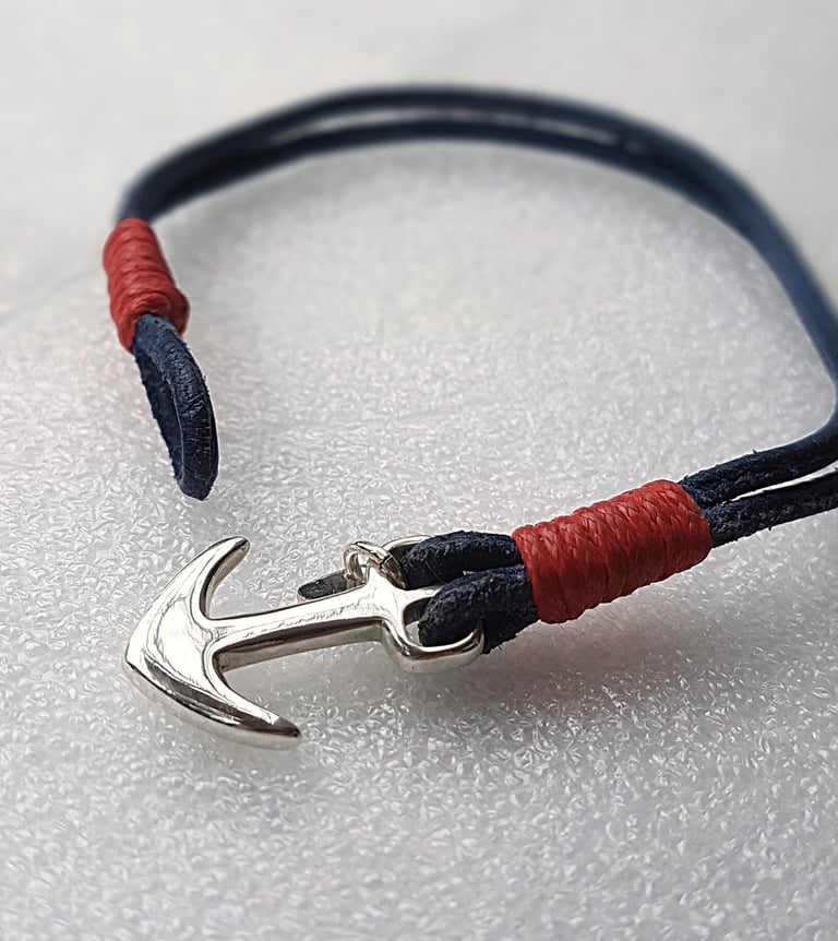 a bracelet bracelet with a silver anchor on a white background