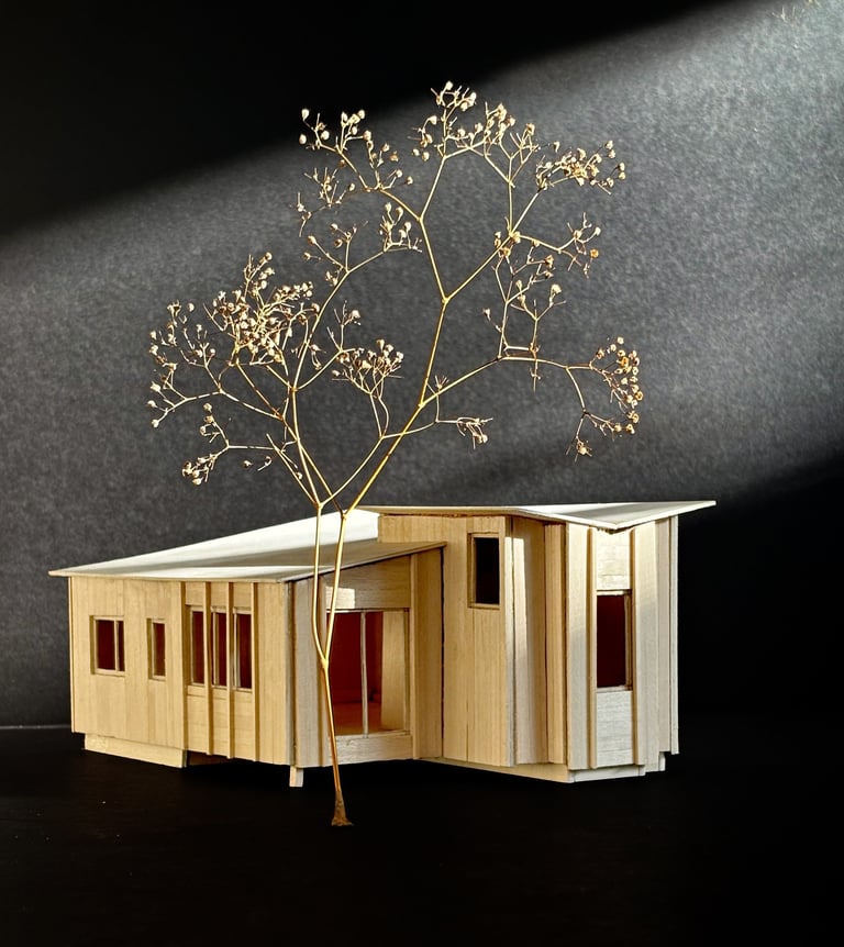 Handcrafted basswood architectural model of a modern cabin design against a dark background.