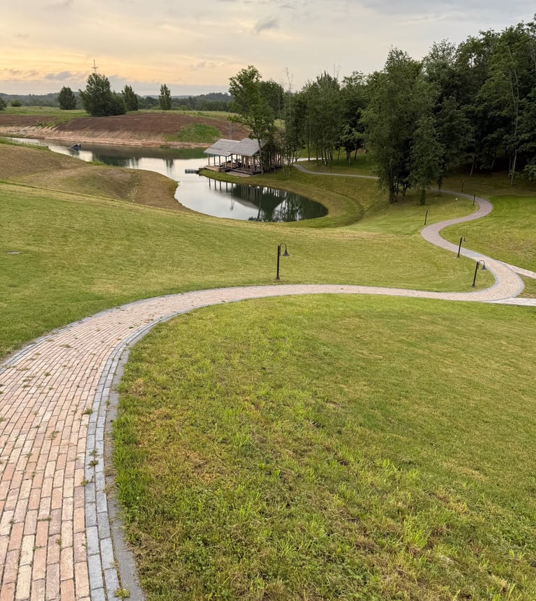 a brick path leading to a pond and a small pond