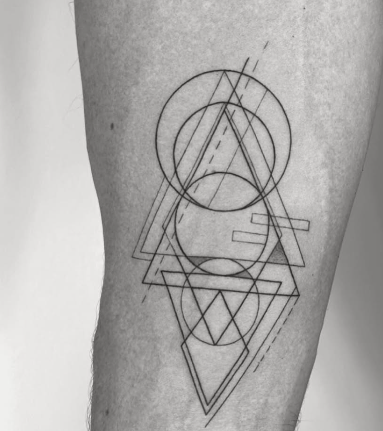 Tatuaje geométrico abstracto con triángulos y círculos superpuestos en pierna madrid