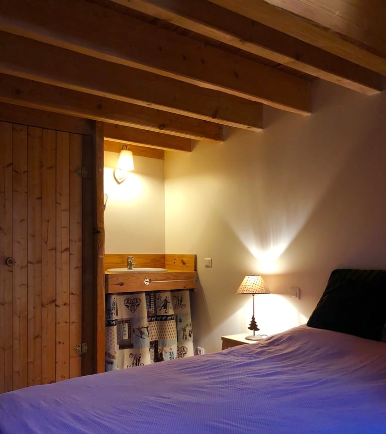 chambre de la grange russell avec un grand lit, un placard et son coin lavabo