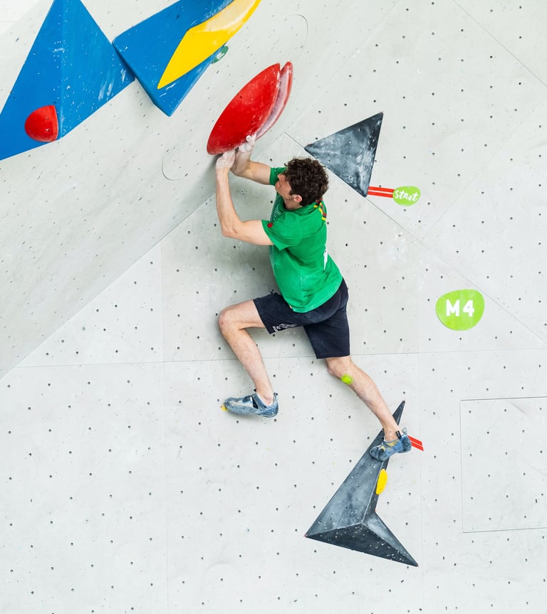 a man bouldering touching a hold with two hands