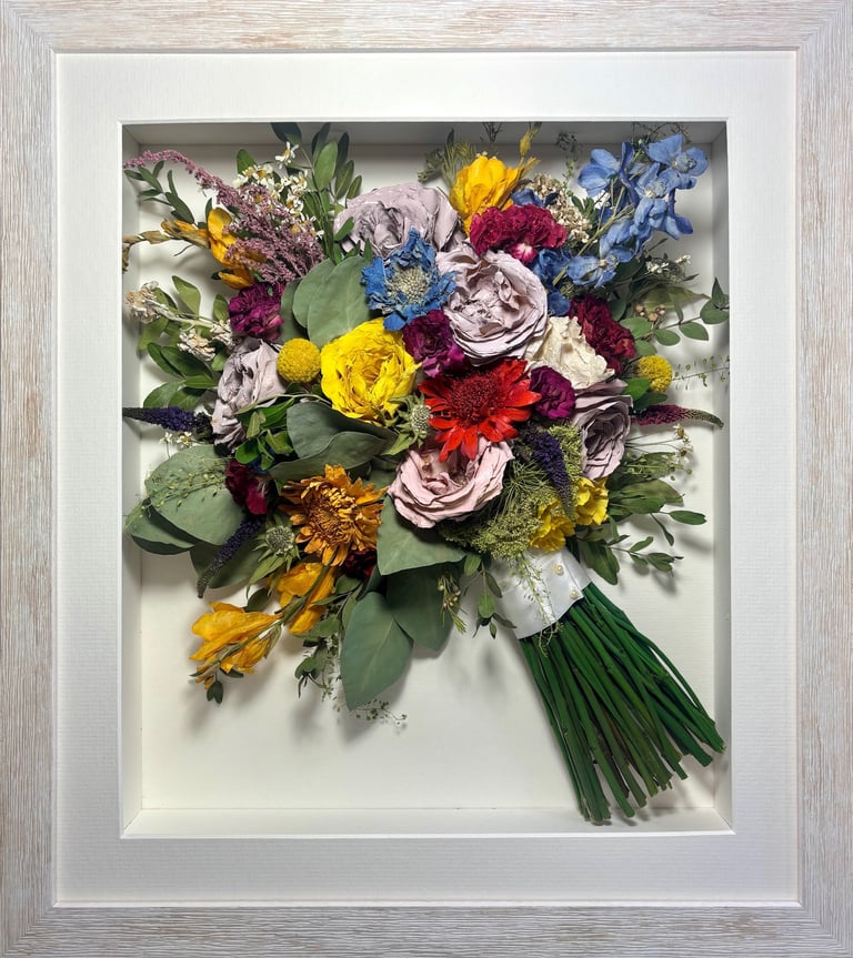 a Side view Style bouquet of flowers  in a thin white frame