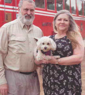 a man and woman standing in front of a red double decker bus