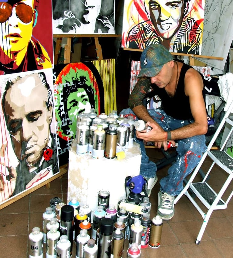 Artista Sérgio Astral pintando quadros personalizados em seu ateliê.