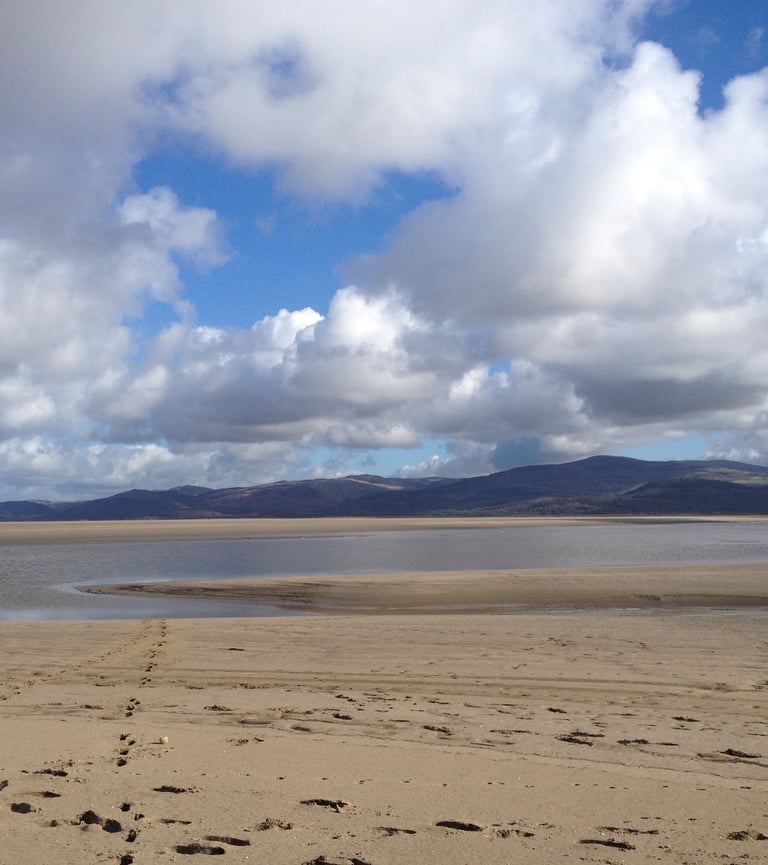 Sand at the dyfi estuary looking at the river Leri channel and hills in the distance