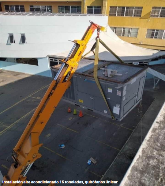 Grúa cargando equipos de aire acondicionado de 15 toneladas para quirófanos de la UNICAR, Guatemala