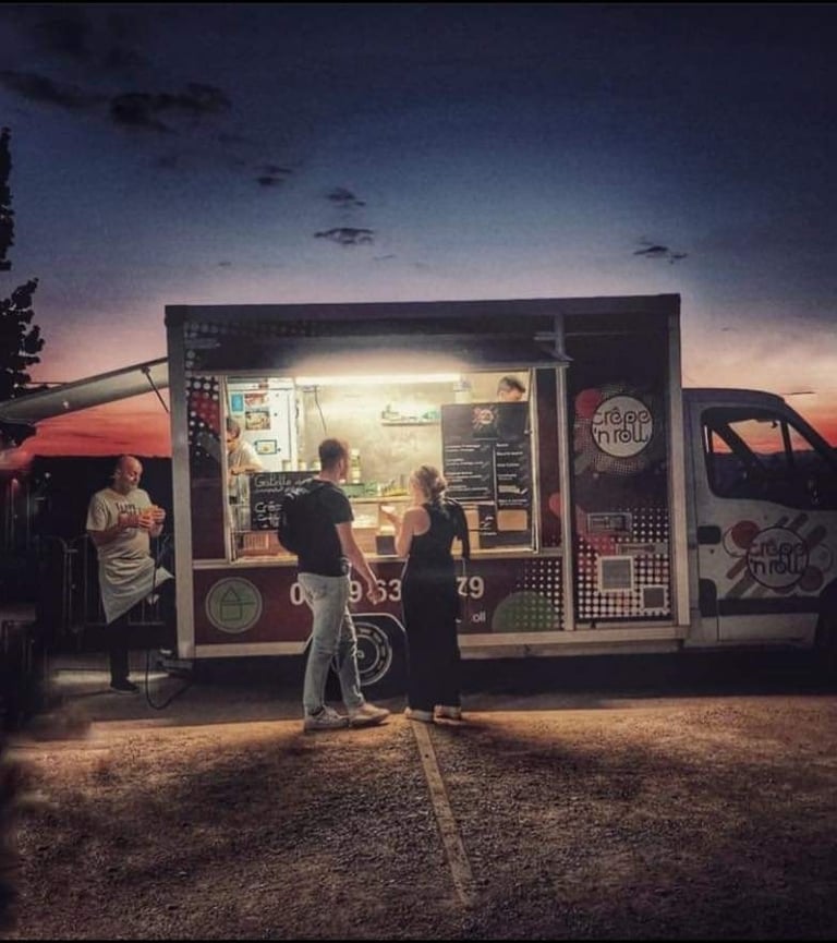 Des clients commandent des crêpes au food truck pendant un évènement musical