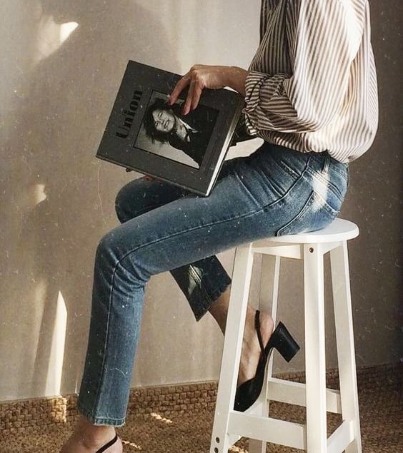 1. Mulher elegante sentada com uma revista, representando clareza e confiança após a consultoriao