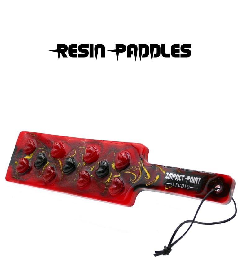 Resin paddle with black and red hearts set into red and black swirly resin with gold glitter.