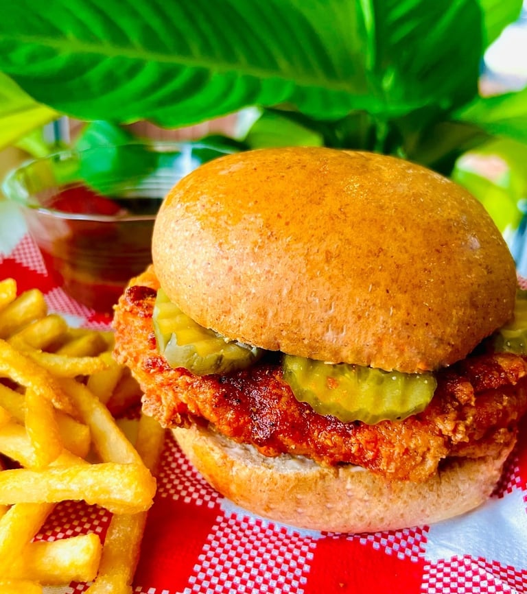 A juicy plant-based patty stacked in a toasted burger bun, layered with pickles, creates a savory