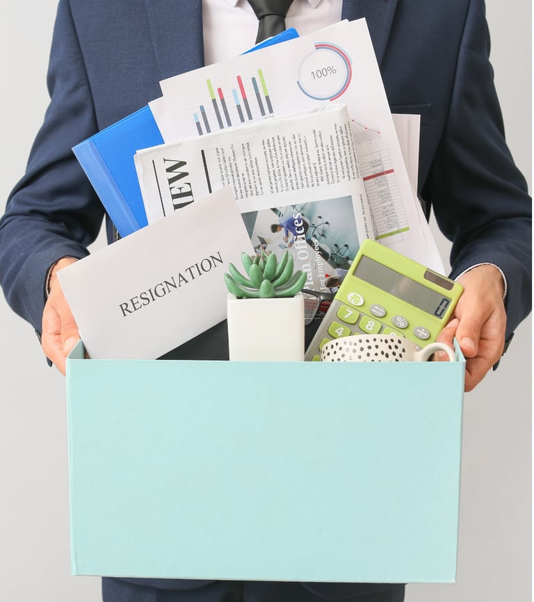 homem demitido segurando uma caixa com seus pertences