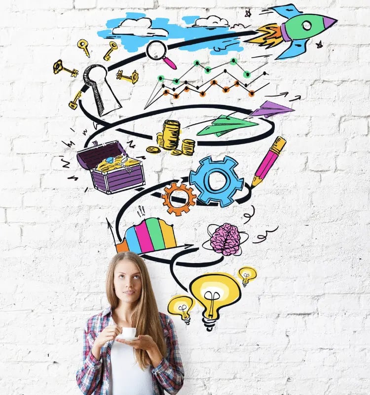 A woman holding a cup of coffee stands in front of a white brick wall with colorful doodles, including a rocket and gears