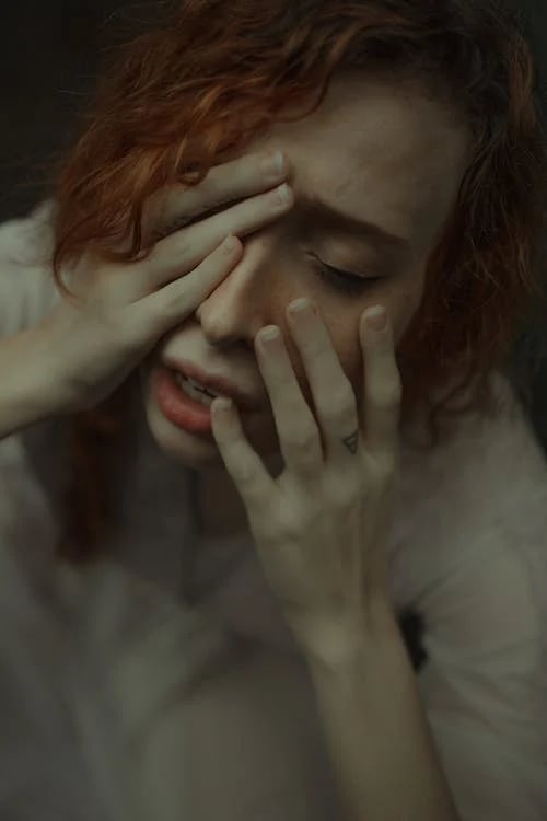 a woman with red hair and a white shirt