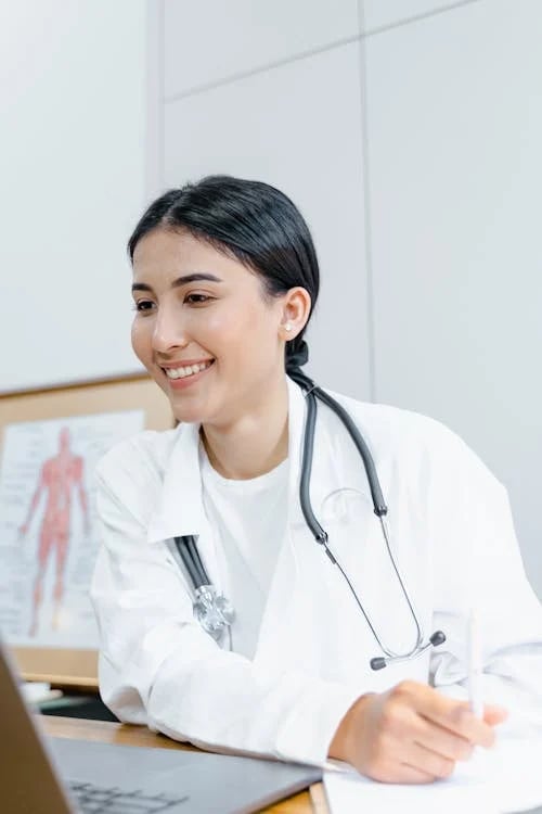 a woman doctor in a white coat and a laptop