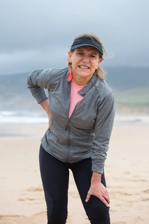 a woman in a gray jacket and pink top hat