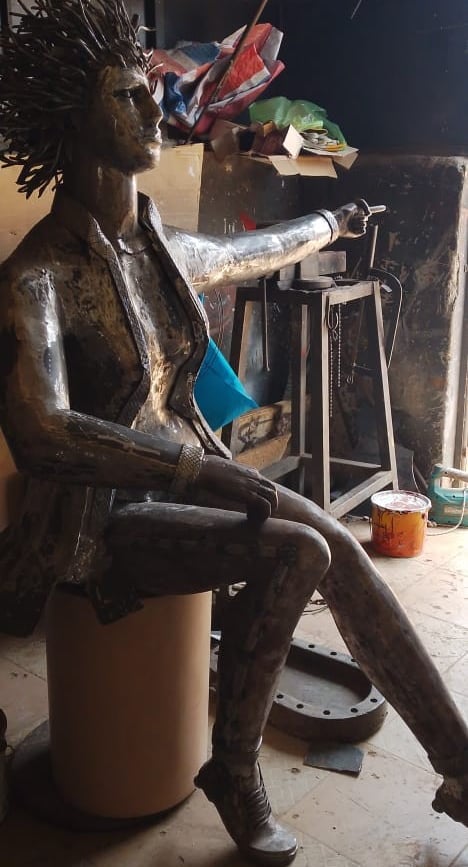 Sculpture métallique réalisée à la main représentant une femme assise aux cheveux hérissés, dans l'a