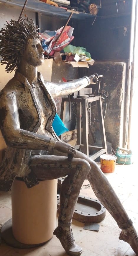 Sculpture métallique réalisée à la main représentant une femme assise aux cheveux hérissés, dans l'a