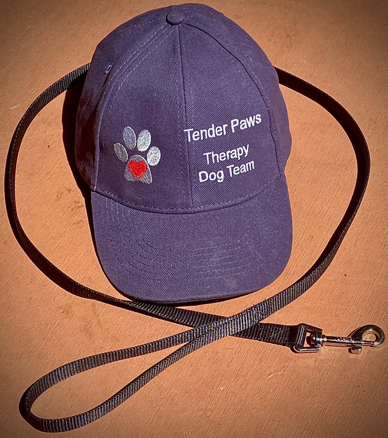 A Tender Paws Therapy Dog Team baseball cap and a dog leash