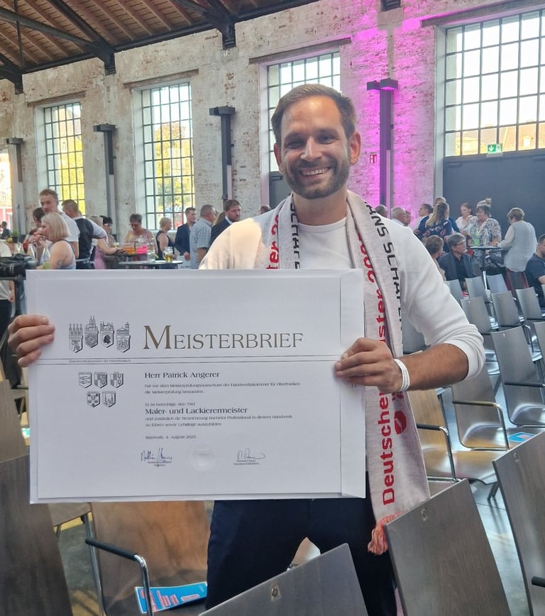 Patrick Angerer der seinen Meisterbrief in der Hand hält