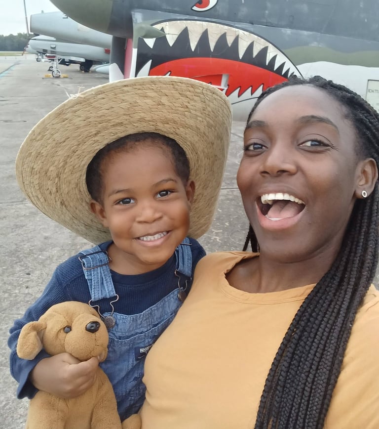 stay at home mom holding son on field trip to air field