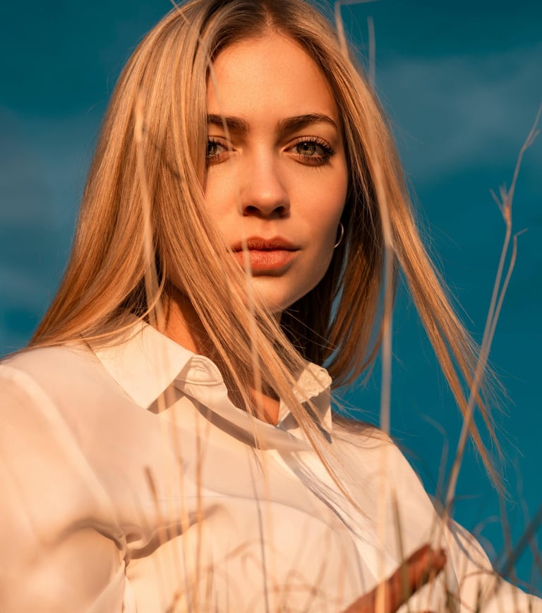 a woman with long blonde hair and a white shirt
