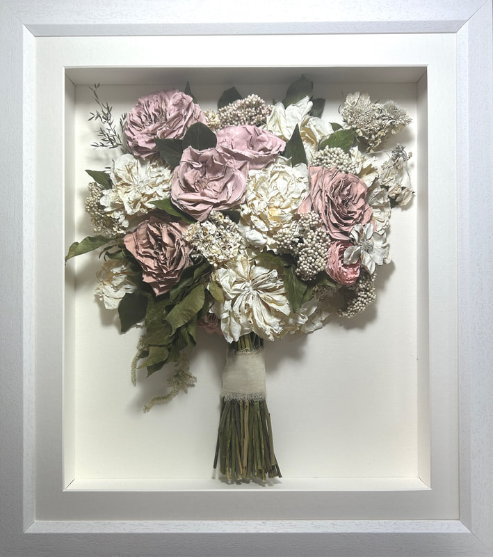 a pink and white side view preserved wedding bouquet in a frame