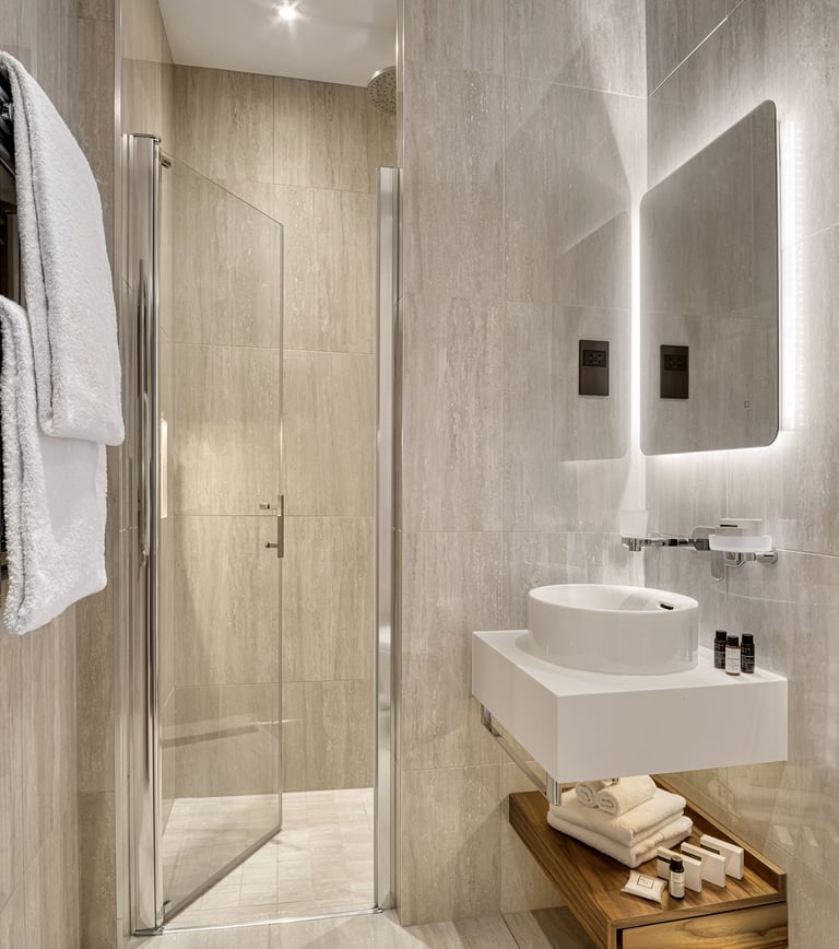 Luxury hotel bathroom – Sleek marble design with premium toiletries and a glass shower.