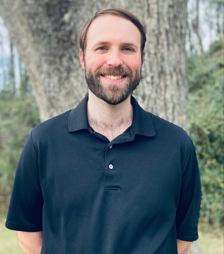 Counselor standing in front of a tree