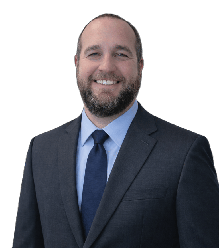 Professional headshot of a smiling man with a beard wearing a grey suit and blue tie.