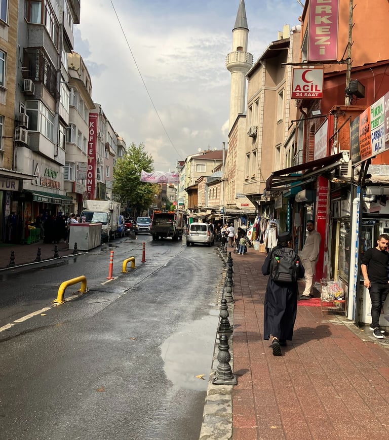 a man walking down a street in istanbul with a car parked on the side of the road