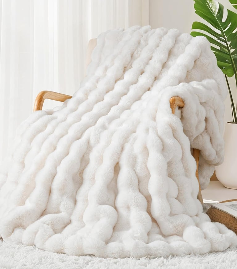 a white blanket on a chair in a room