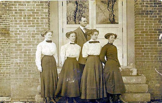 a group of people standing in front of a brick building