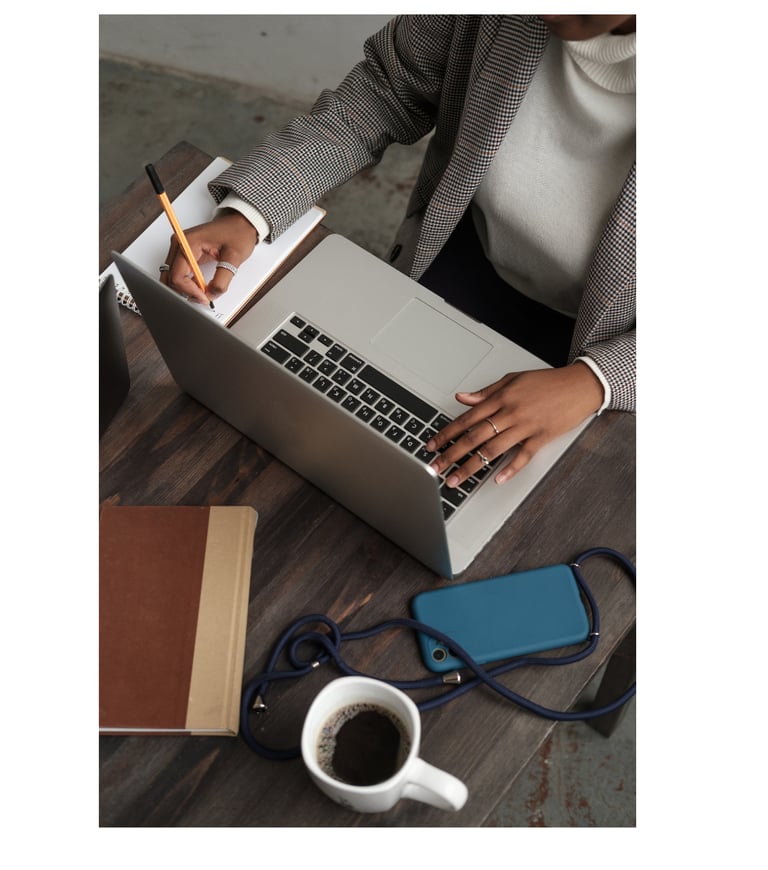 Personne écrivant dans un carnet tout en travaillant sur un ordinateur portable, Réflexion 