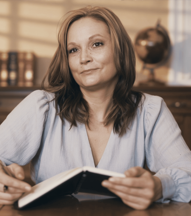 a woman sitting at a table with a book and a book