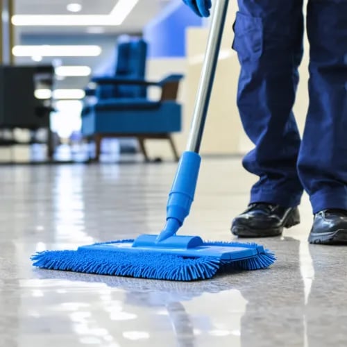 a person cleaning a floor with a broom