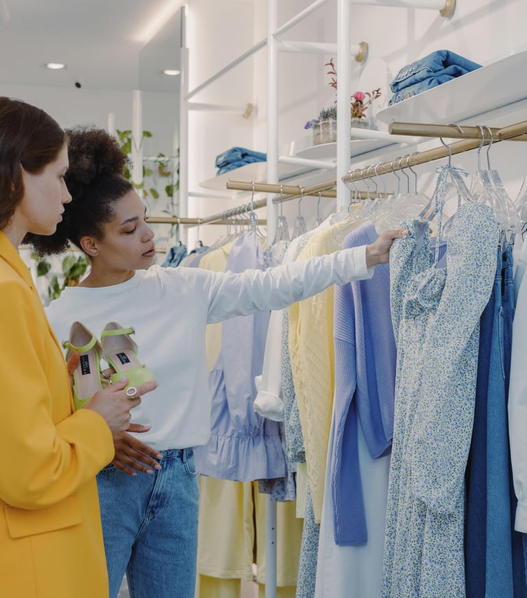Consultora de imagem auxiliando cliente na escolha de roupas durante uma consultoria de compras.