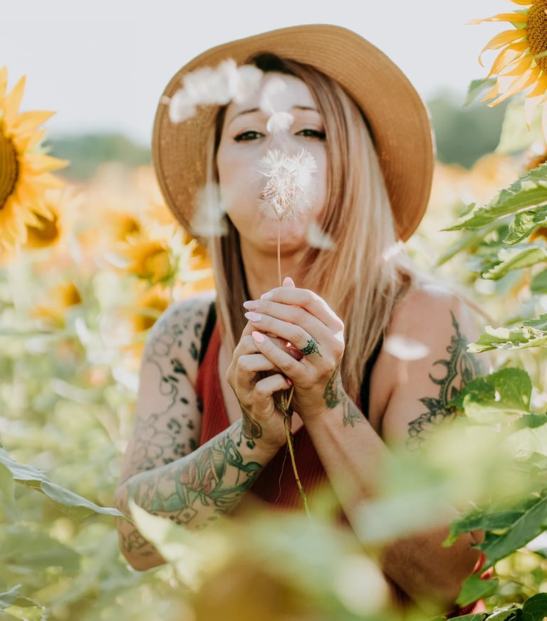 une femme souffle sur un pissenlit