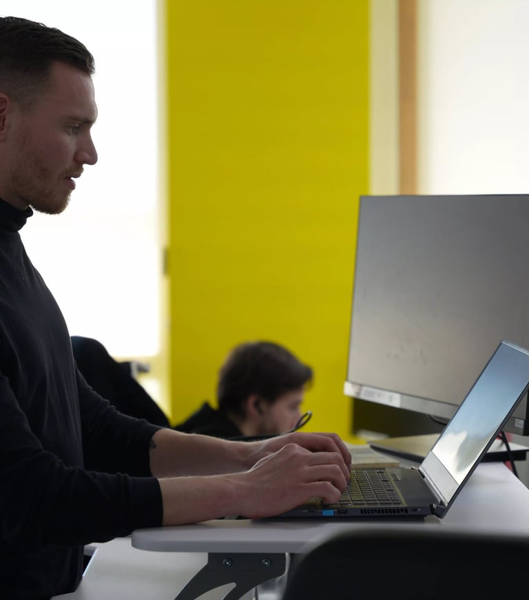 Salarié debout travaillant sur son ordinateur dans l'open space
