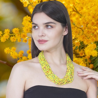 a woman wearing bright bohemain handmade yellow necklace