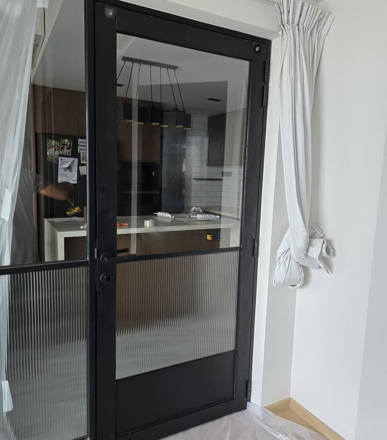 Modern bathroom interior featuring grey wall tiles, a frosted window, and a glass shower partition.