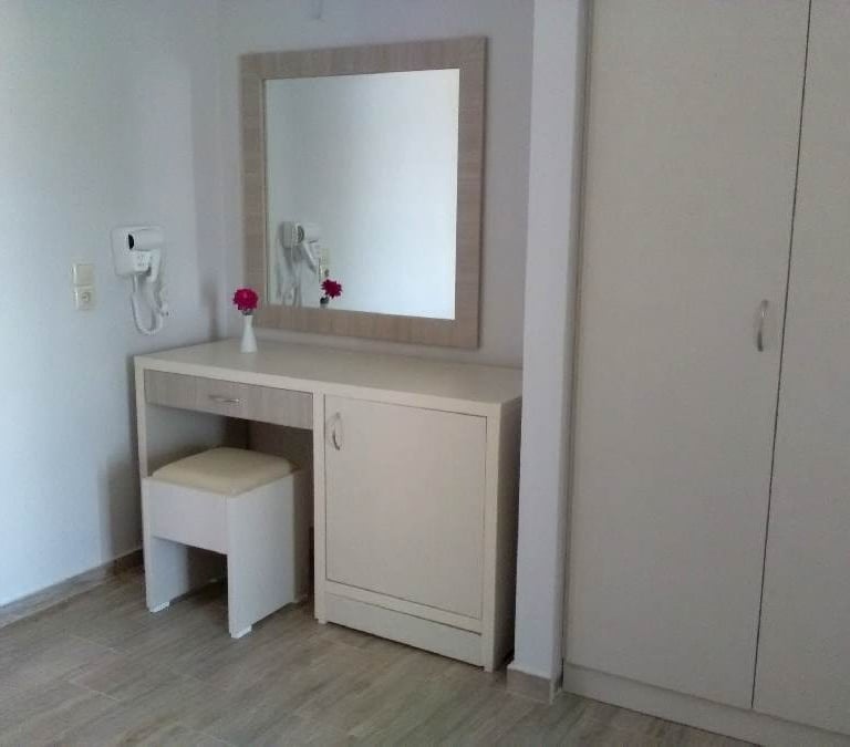 a white vanity with a mirror and a mirror
