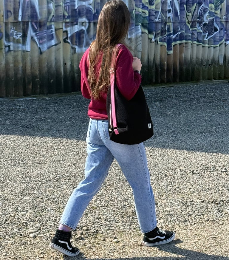 Bolso mochila negro con correas rosas, con gran capacidad y un estilo urbano