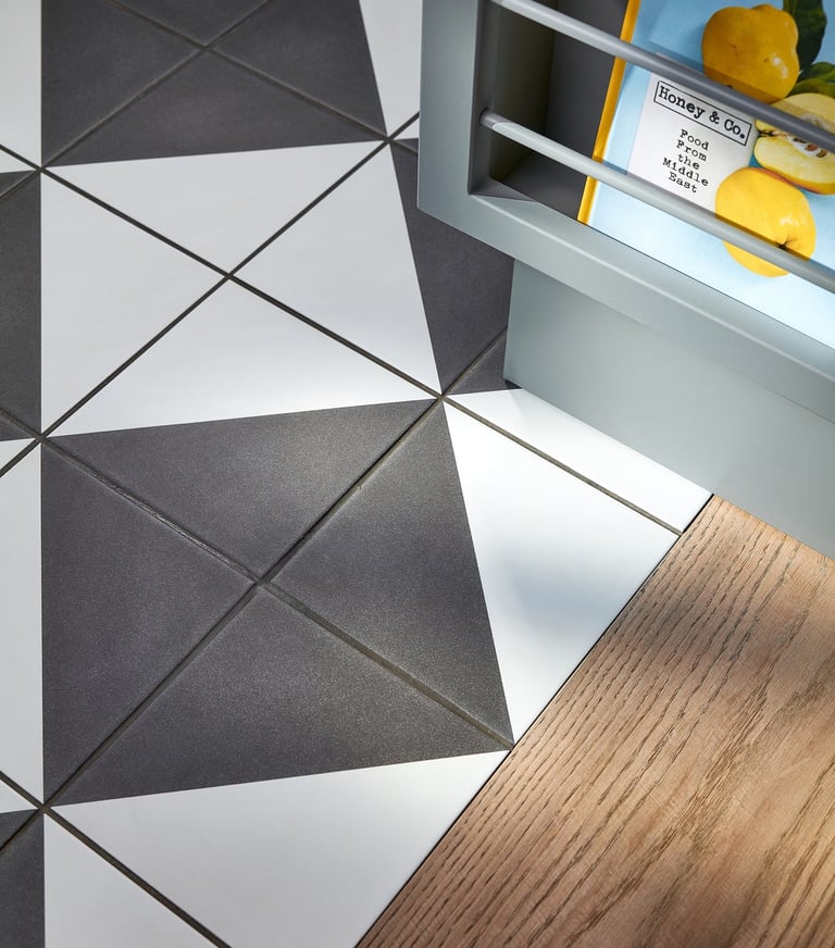 Black and white floor tiles laid in a diamond pattern with oak wood flooring