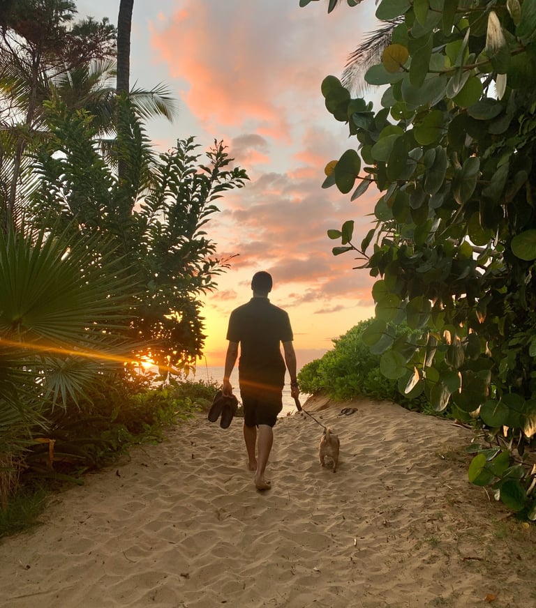 a man walking down a path with a dog