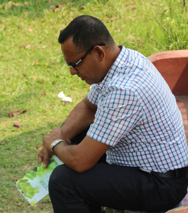 a man sitting on a bench in a park