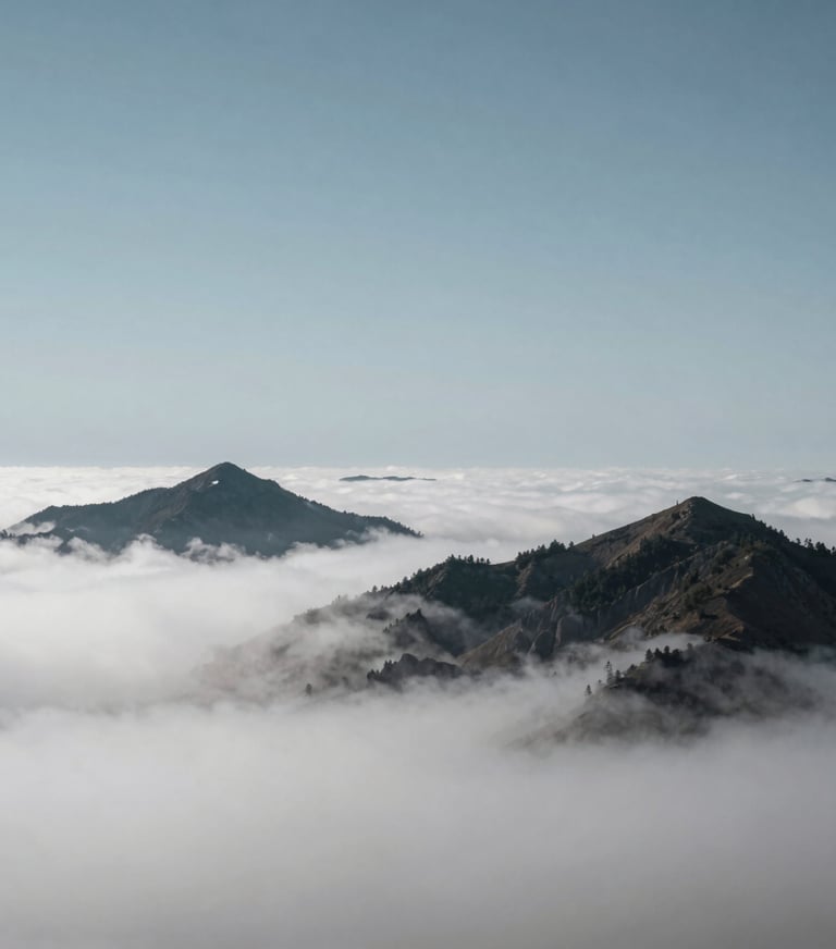 A breathtaking landscape of mountain peaks emerging through a layer of soft white clouds, minimalist composition, steel blue grey sky, International / Western.