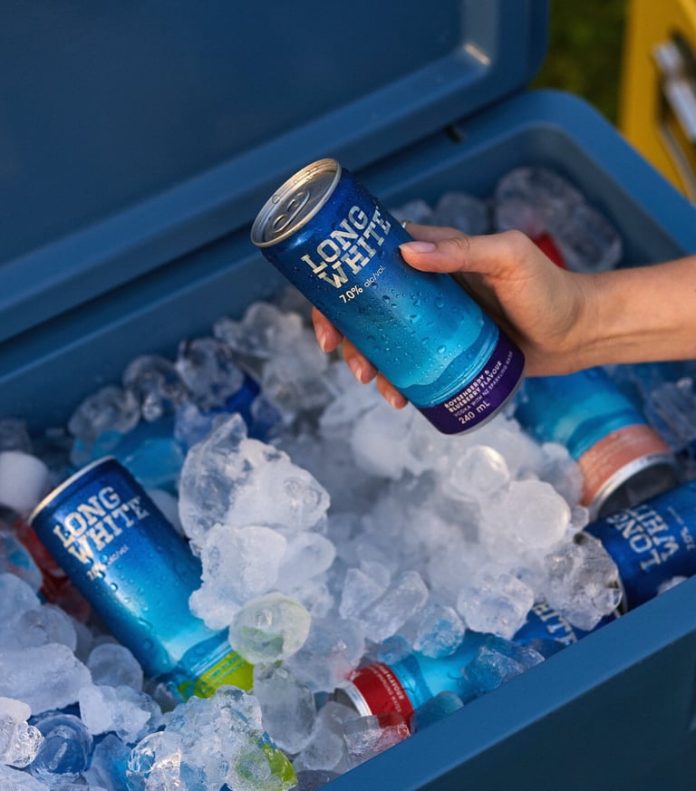 Product photography - a person holding a can of long white over an ice bucket