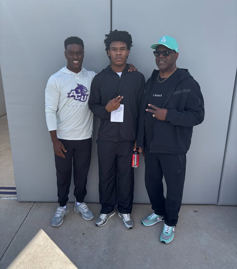 Coach DJ Williams, Adairian Alexander, and Coach Jiles at the ACU game being offered a Scholarships.